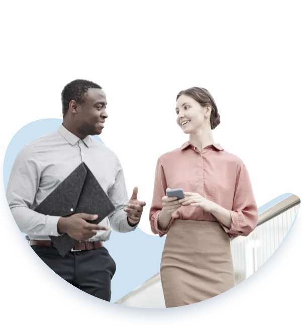 Two professionals engaged in a conversation; a man holding a folder gestures while speaking to a woman who holds a smartphone. Both display attentive body language, exemplifying effective communication in a leadership setting.